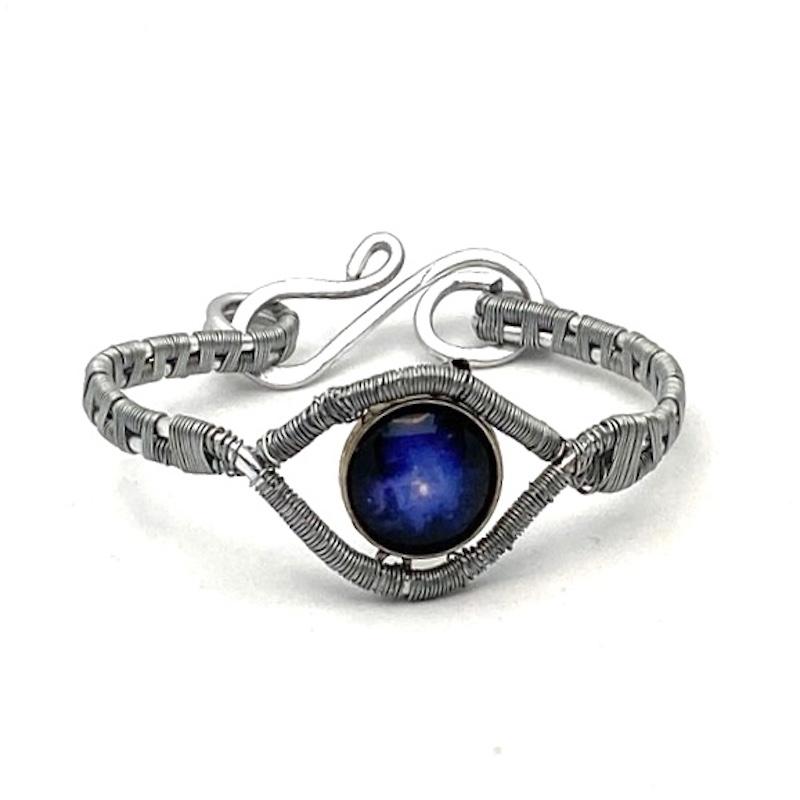 A wire wrapped bracelet consisting of a blue galaxy focal