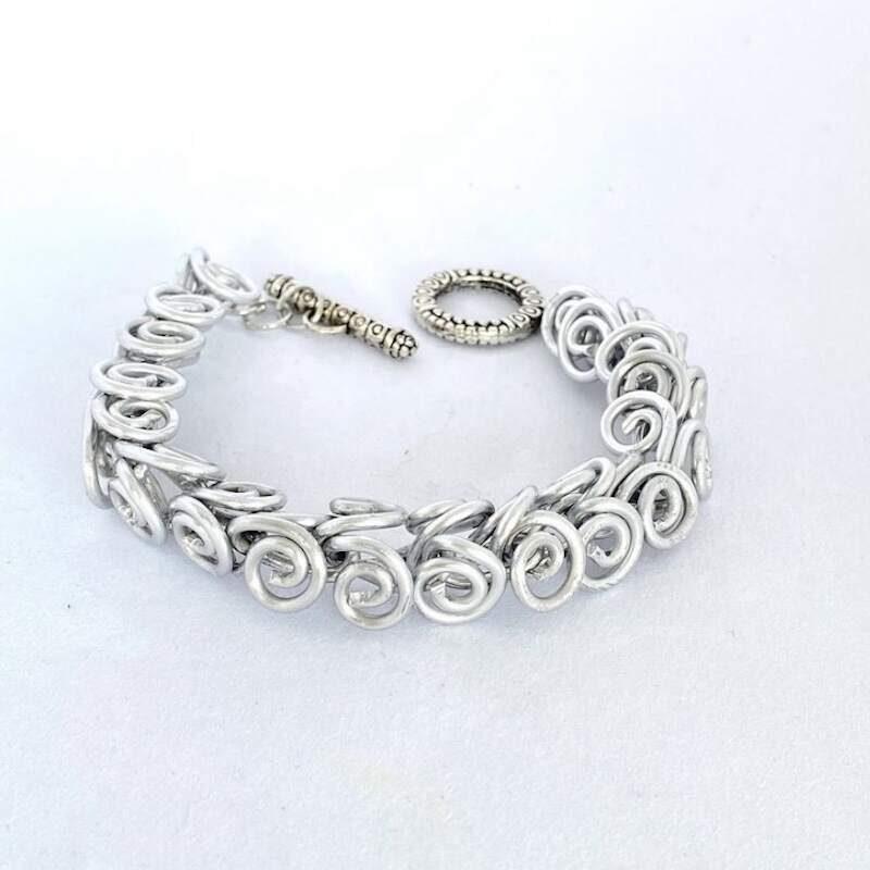A silver bracelet comprised of scrolled links