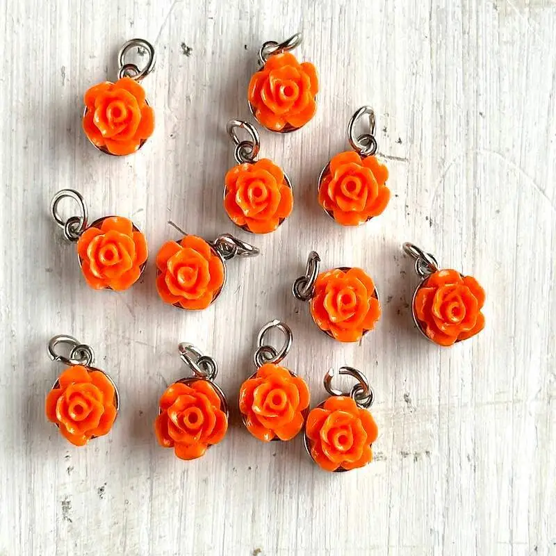 A group of orange colored rose charms