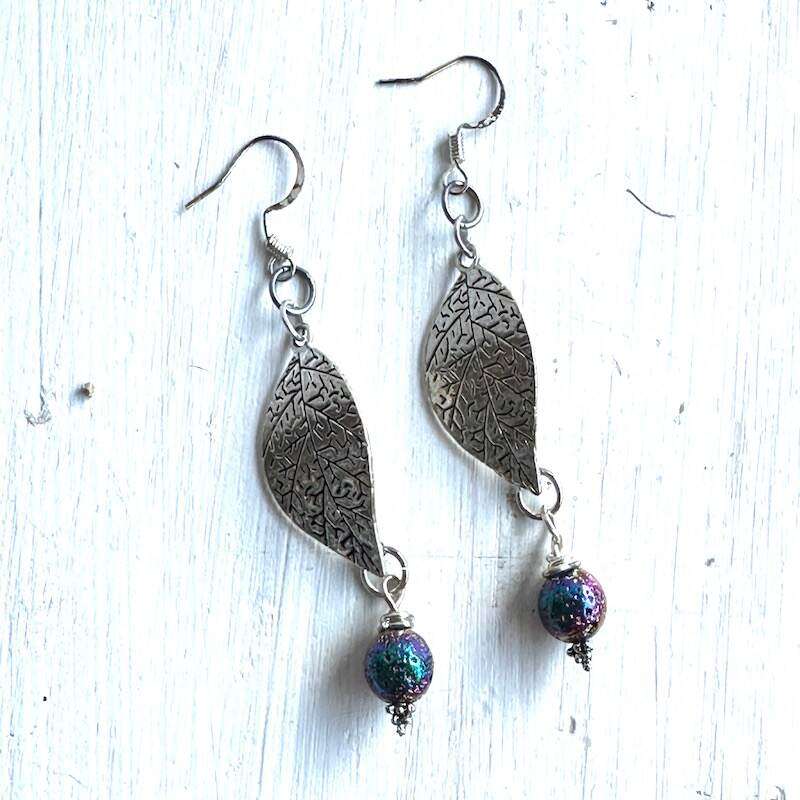 A pair of silver leaf earrings with titanium plated lava stone drops