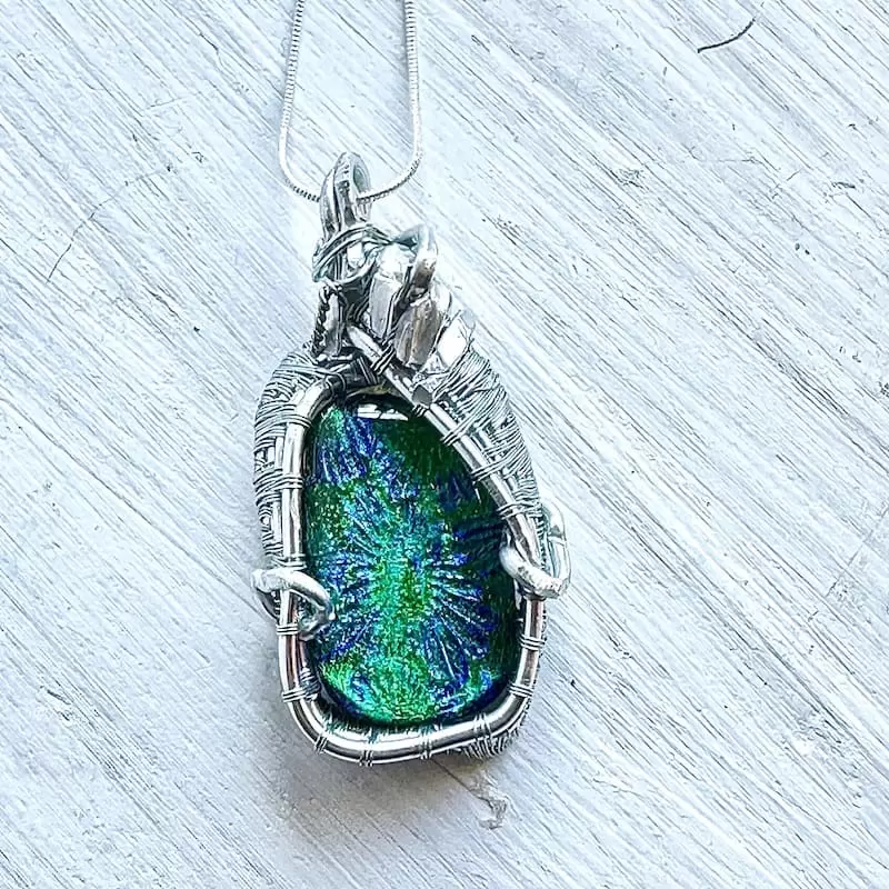 A necklace made of blue and green dichroic glass and wirework